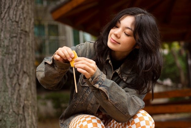 Foto gratuita mujer joven con galleta dalgona