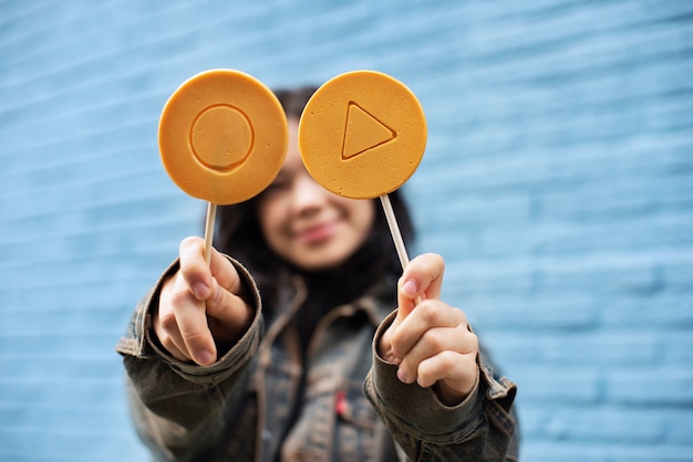 Foto gratuita mujer joven con galleta dalgona