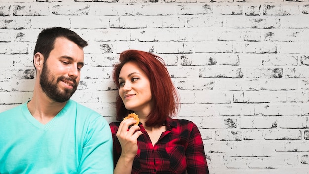 Foto gratuita mujer joven con galletas mirando a su novio