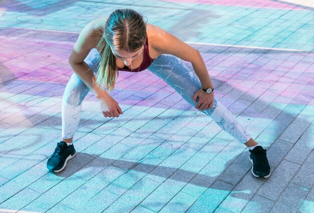 Mujer joven en el gimnasio haciendo ejercicios de estiramiento