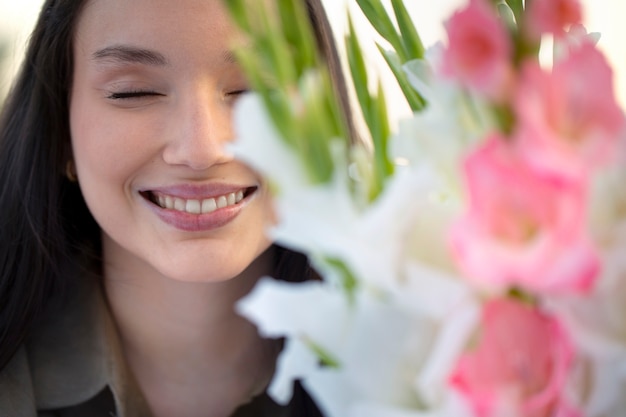 Foto gratuita mujer joven con gladiolos en la naturaleza.