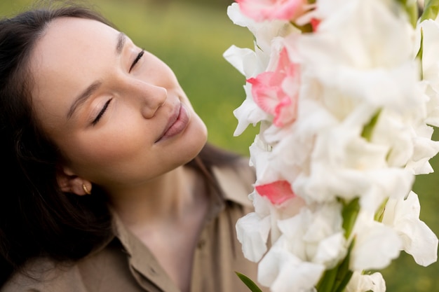 Foto gratuita mujer joven con gladiolos en la naturaleza.