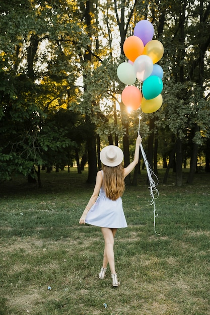 Mujer joven con globos al aire libre