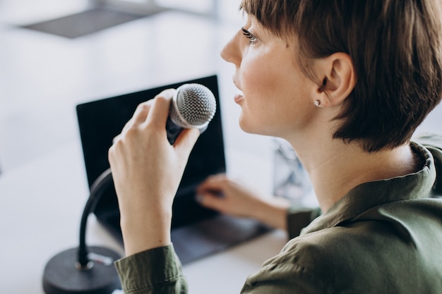 Mujer joven grabando voz actuando en el estudio