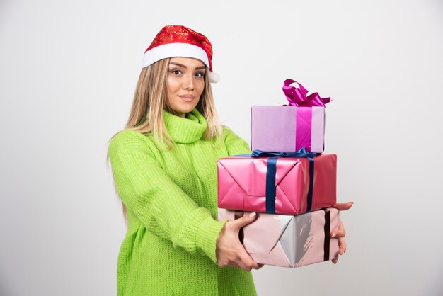 Mujer joven con una gran cantidad de regalos festivos de Navidad.