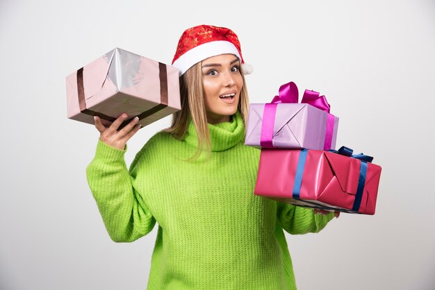 Mujer joven con una gran cantidad de regalos festivos de Navidad.