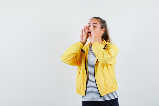 Foto gratuita mujer joven gritando o anunciando algo en camiseta, chaqueta, vista frontal.