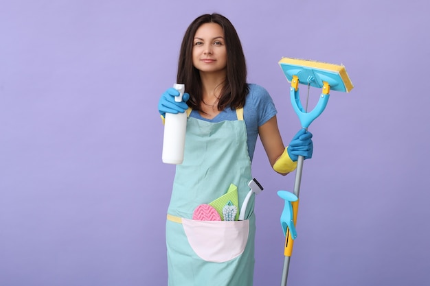 Mujer joven con guantes de goma, listo para limpiar