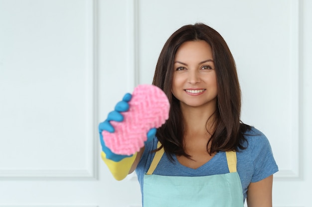 Mujer joven con guantes de goma, listo para limpiar