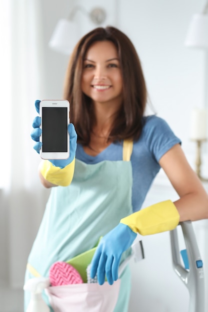 Mujer joven con guantes de goma mostrando smartphone