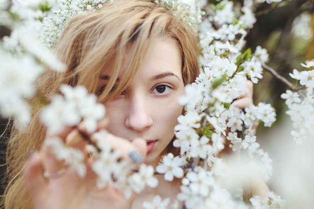 Mujer joven guapa con flores blancas