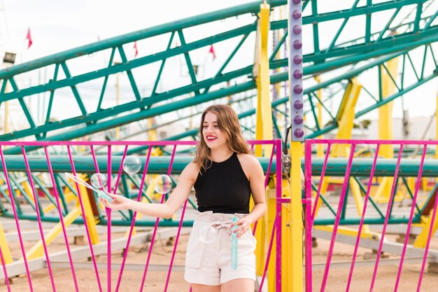 Mujer joven guapa en el parque de atracciones