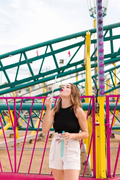 Mujer joven guapa en el parque de atracciones