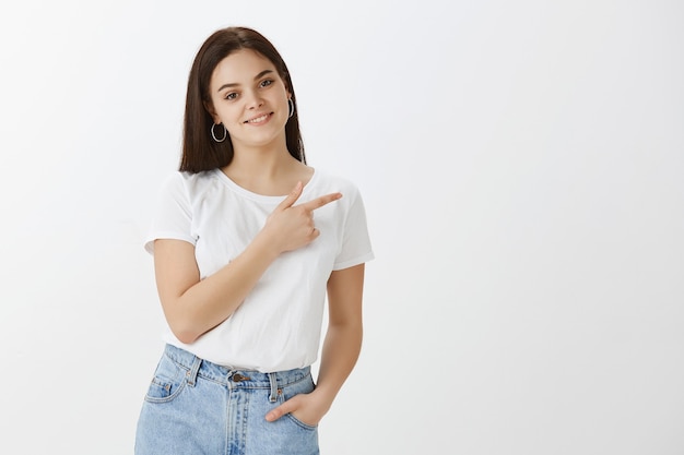 Mujer joven guapa posando contra la pared blanca