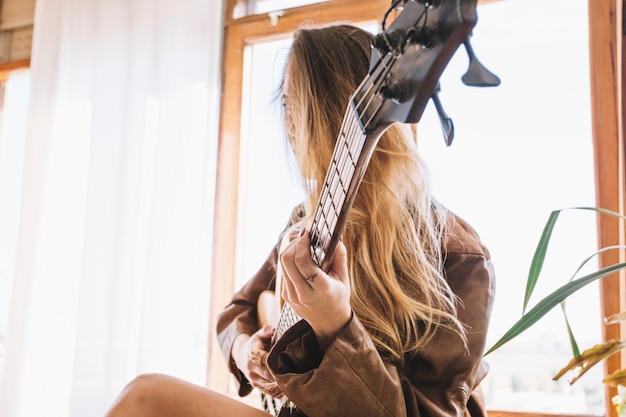 Mujer joven con guitarra eléctrica