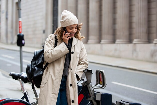Mujer joven hablando por su teléfono inteligente en la ciudad