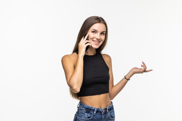 Mujer joven hablando por teléfono celular, mirando hacia arriba, sobre blanco