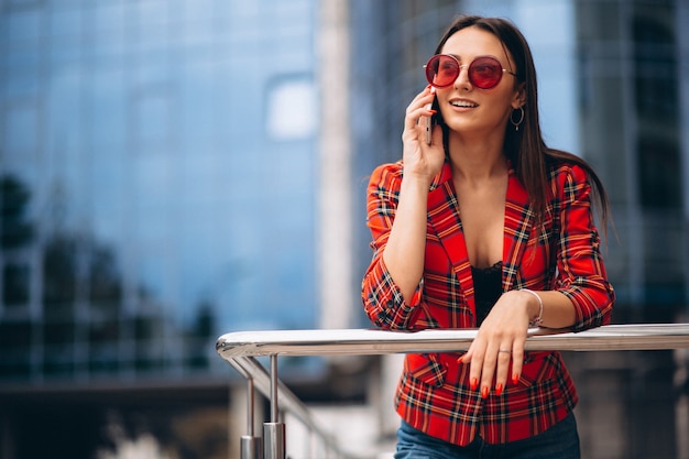 Foto gratuita mujer joven hablando por teléfono en el centro de la oficina