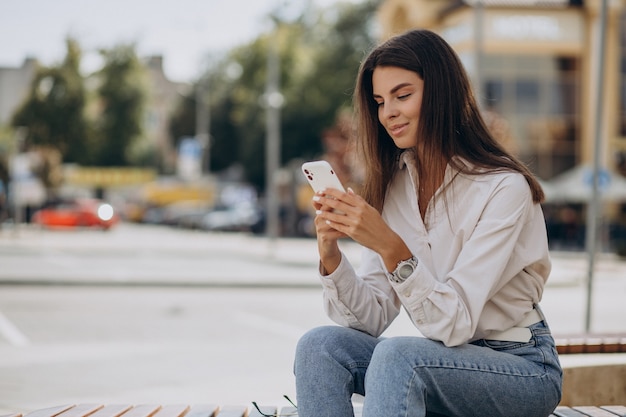 Foto gratuita mujer joven hablando por teléfono fuera de la calle