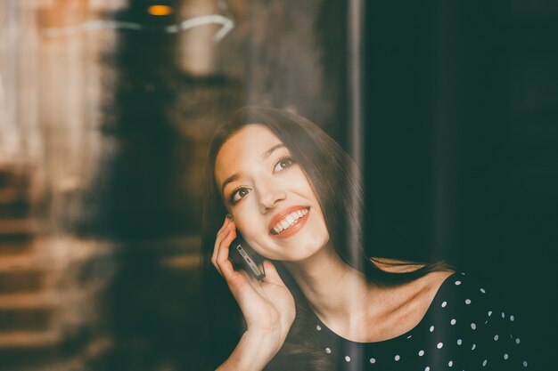 Mujer joven hablando por teléfono con una gran sonrisa