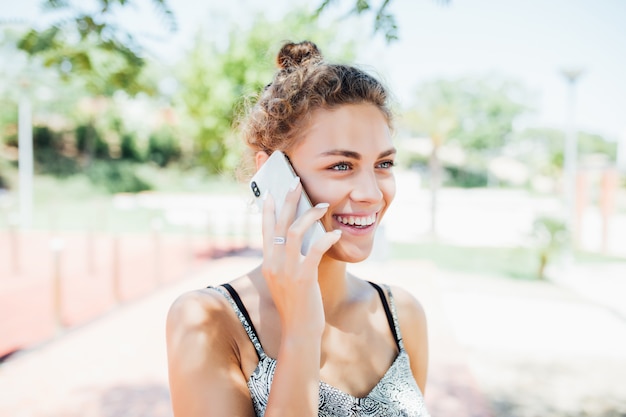 Mujer joven hablando por teléfono móvil en la calle