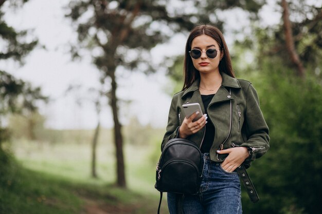 Mujer joven hablando por teléfono en el parque