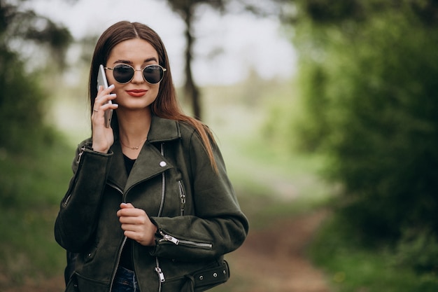 Mujer joven hablando por teléfono en el parque
