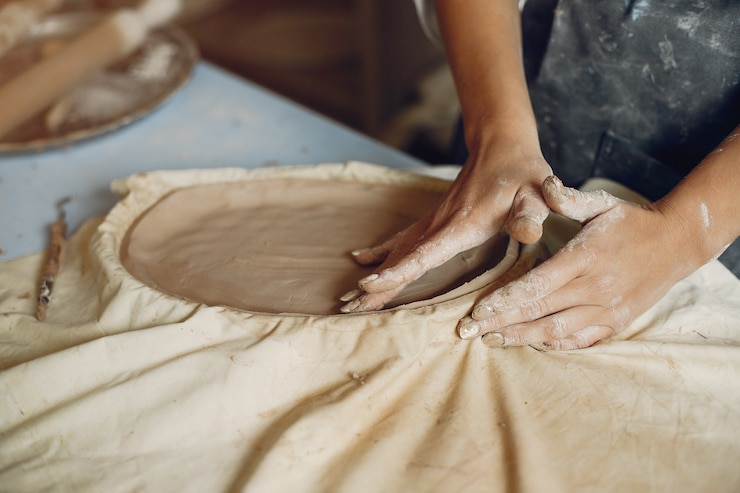 Foto gratuito mujer joven hace cerámica en taller