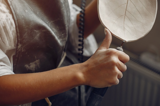 Foto gratuita mujer joven hace cerámica en taller