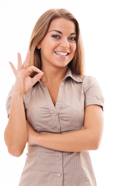 Mujer joven haciendo bien gesto con la mano. ¡Bien hecho!