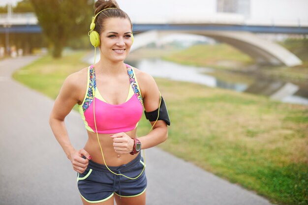 Mujer joven haciendo ejercicio al aire libre. El parque es mi lugar favorito para hacer jogging.