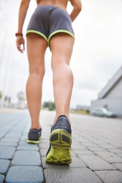 Foto gratuita mujer joven haciendo ejercicio al aire libre. sección baja de mujer corriente