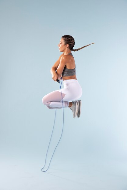 Mujer joven haciendo ejercicio con una cuerda para saltar