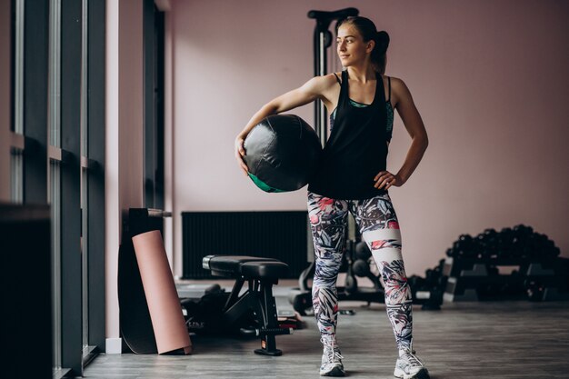 Mujer joven haciendo ejercicio en el gimnasio con peso