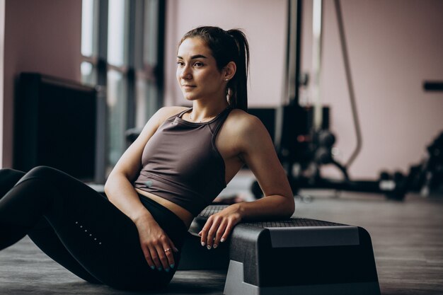 Mujer joven haciendo ejercicio en el gimnasio con peso