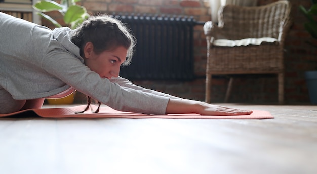 Foto gratuita mujer joven haciendo ejercicios en casa