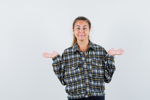 Foto gratuita mujer joven haciendo gesto de marco en camisa a cuadros y mirando confiado, vista frontal.