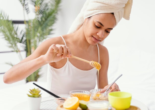 Mujer joven haciendo una mascarilla natural en casa