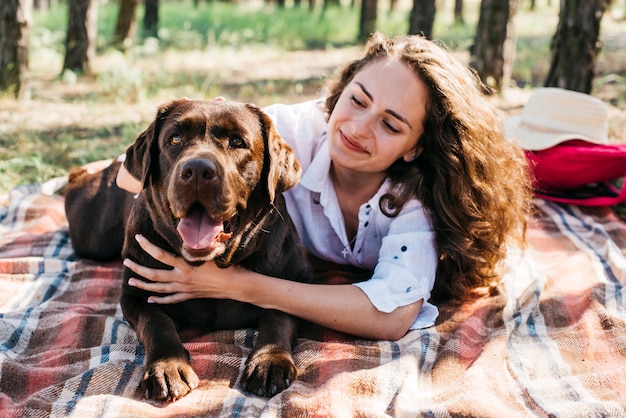 Mujer joven haciendo un picnic con su perro