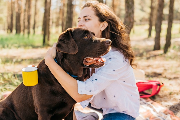 Mujer joven haciendo un picnic con su perro