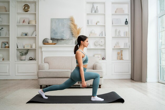 Mujer joven haciendo su entrenamiento en casa en una colchoneta de fitness