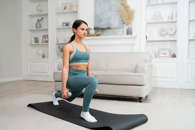 Mujer joven haciendo su entrenamiento en casa en una colchoneta de fitness