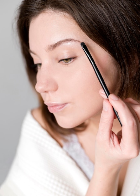 Mujer joven haciendo sus cejas