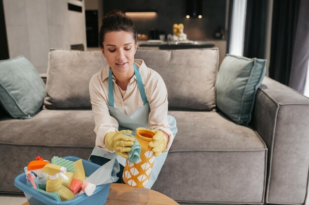 Mujer joven haciendo tareas domésticas y luciendo ocupada