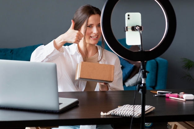 Foto gratuita mujer joven haciendo un vlog de unboxing