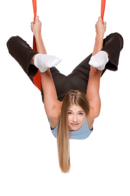 Mujer joven haciendo yoga aéreo antigravedad