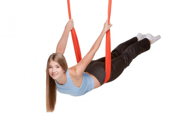 Mujer joven haciendo yoga aéreo antigravedad