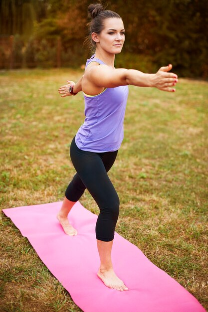 Mujer joven haciendo yoga afuera. Esta posición solo puede parecer fácil