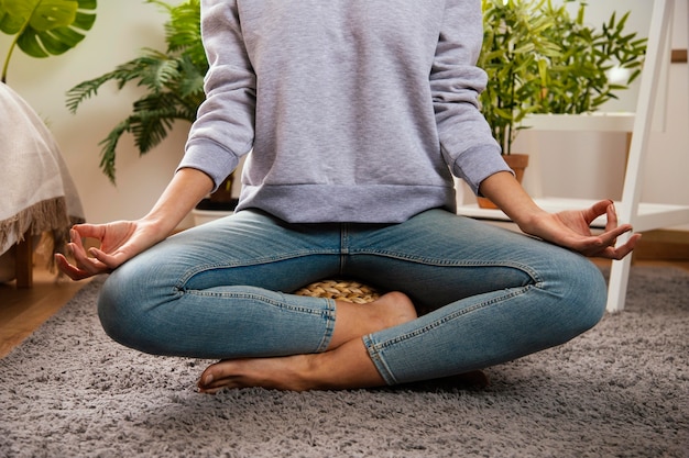 Mujer joven haciendo yoga en casa