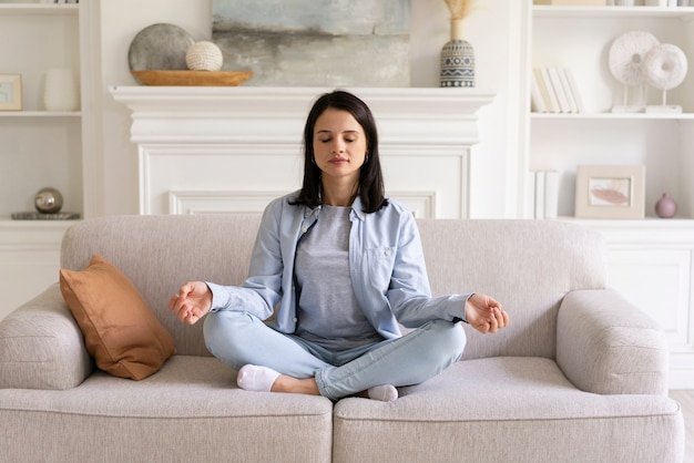 Mujer joven haciendo yoga en casa